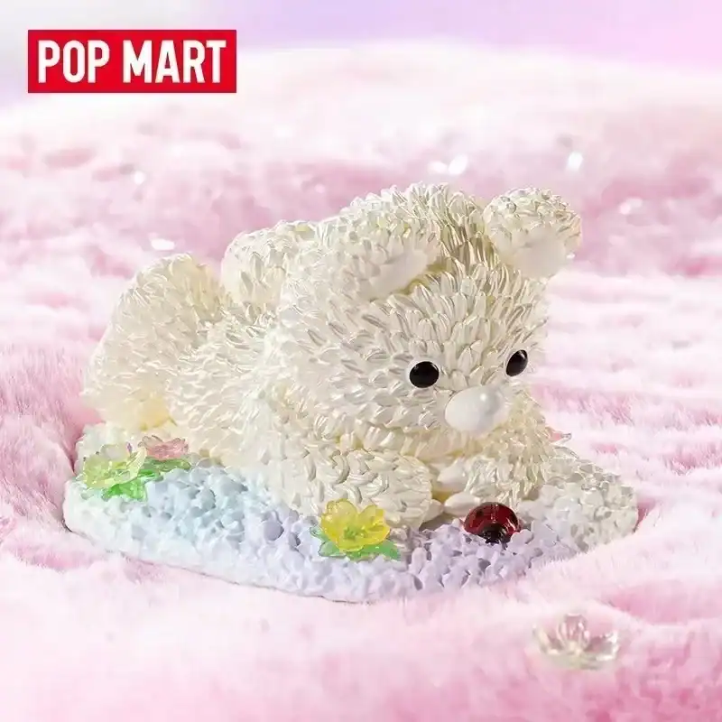 Cute bear figurine made of intricate white floral designs, displayed on a soft pink background.