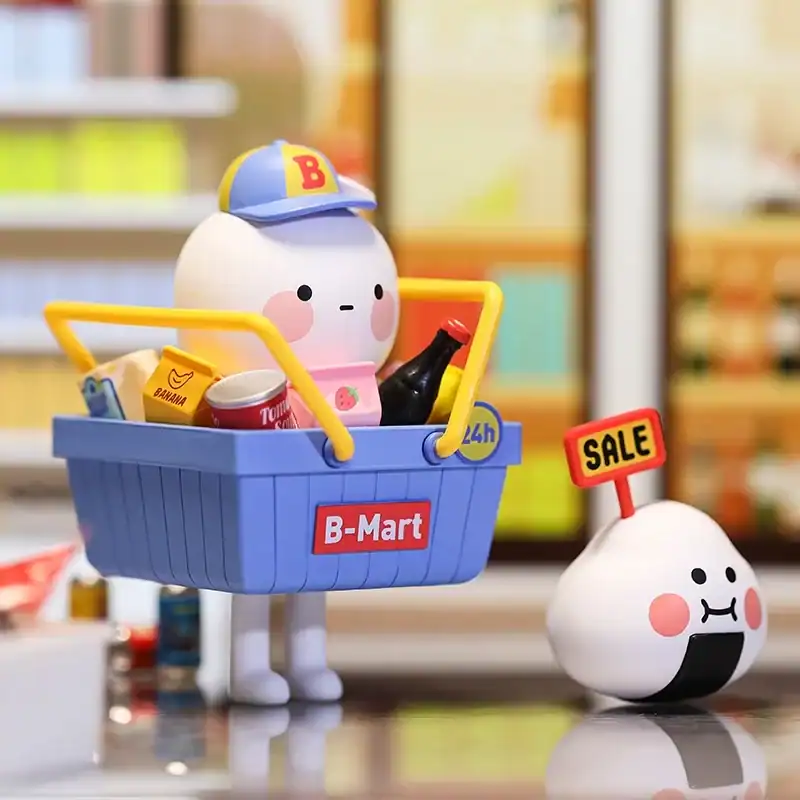 A cute cartoon character with a shopping cart filled with snacks, wearing a cap with a B, representing merchandise for Ariana Grande fans.