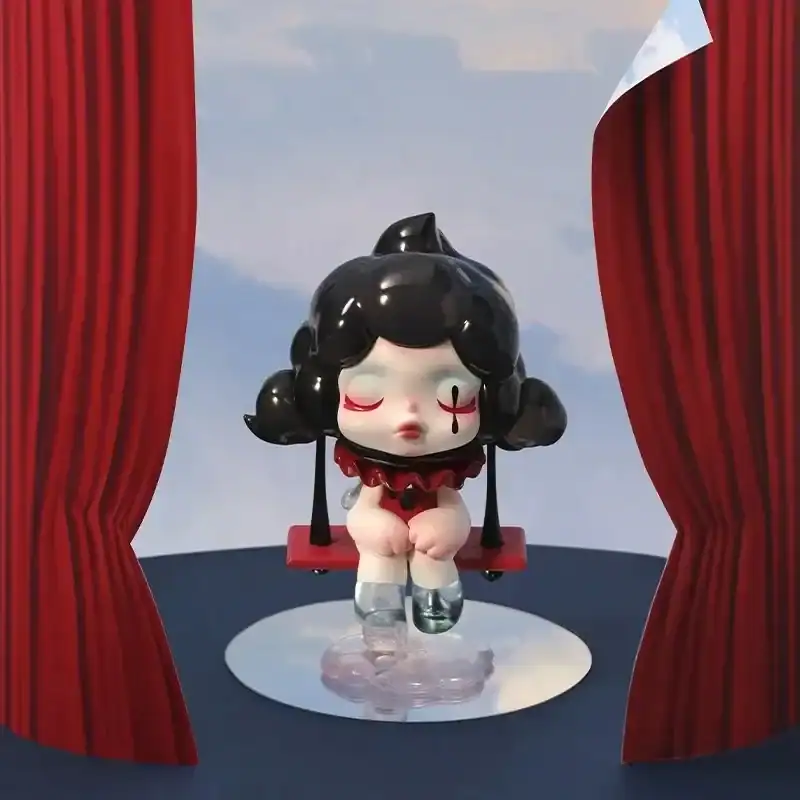 Ariana Grande merch collectible figurine with a dark hairstyle and closed eyes, sitting on a red swing with a blue sky background.